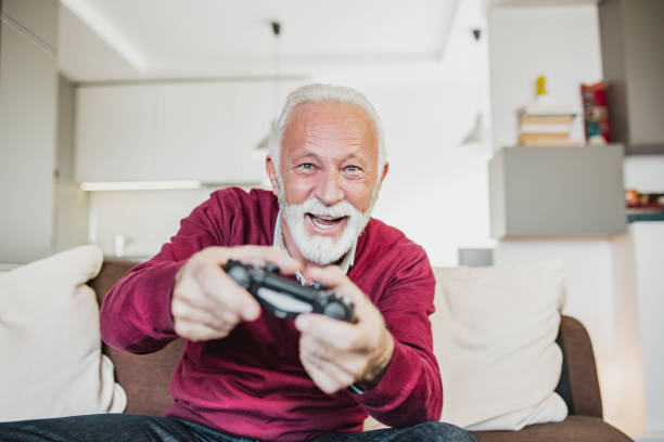 istock Senior man playing video games at home 1220527395