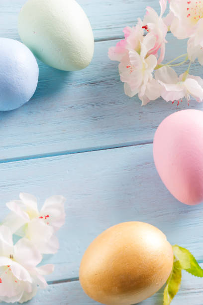 istock Close-up greeting Easter card from handcraft painted eggs and tenter flowers on a light blue wooden background. 1220527947
