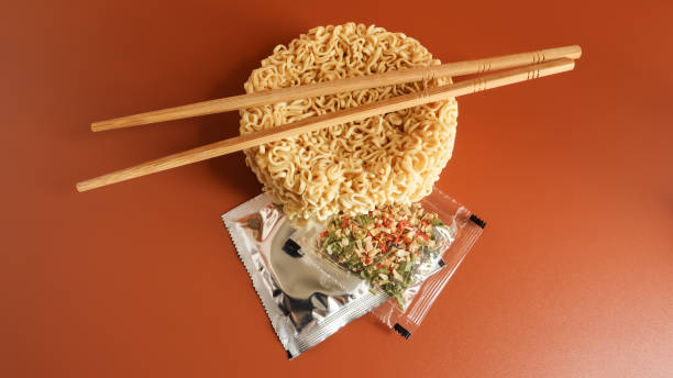 Raw instant noodles with chopsticks and spices. Copy space asian food. pasta, for the preparation of which it is enough to pour boiling water and wait a few minutes. flavored spaghetti Raw instant noodles with chopsticks and spices. Copy space asian food. pasta, for the preparation of which it is enough to pour boiling water and wait a few minutes. flavored spaghetti soup photos stock pictures, royalty-free photos & images