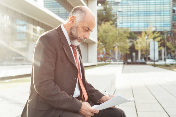 istock Side view of concentrated businessman working with reports 1220529001