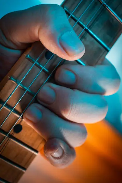 Photo of Close up of guitarist hand playing electric guitar