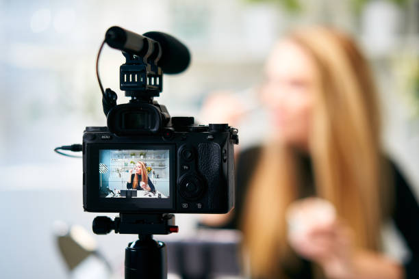 Display of camera recording video blog for blonde beauty blogger woman with make-up at home studio. Influencer vlogger girl live streaming cosmetics masterclass. Online learning and marketing concept stock photo
