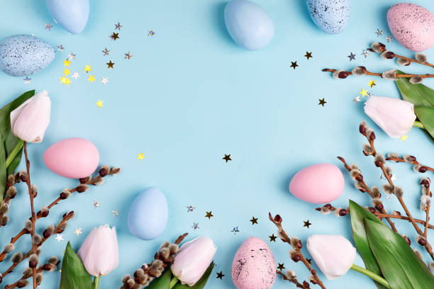 istock Festive frame with Easter handcraft painted eggs and tulips flowers border on a light blue background. 1220529824