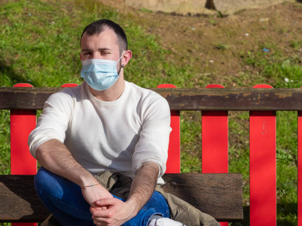 istock Young man protecting himself with a mask in a park. 1220529952