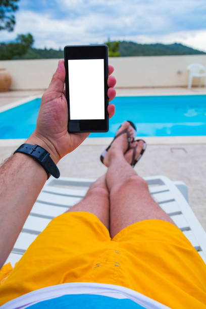 istock Man using cellphone near the swimming pool. 1220530911