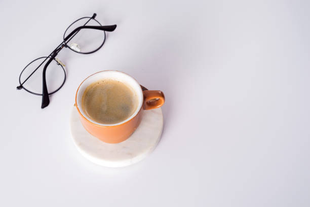 istock Office desk table with coffee cup, pen and glasses. Top view with copy space 1220531175