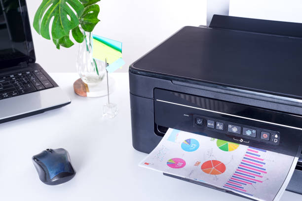 istock Printer and paper isolated on a white home table 1220531240