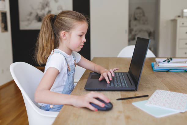 istock girl working on her laptop during home schooling 1220531396