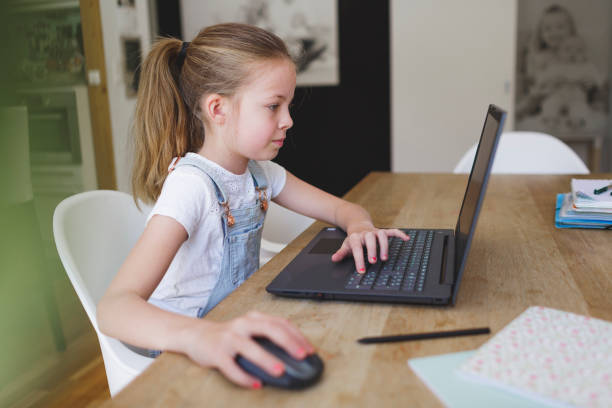 istock girl working on her laptop during home schooling 1220531477