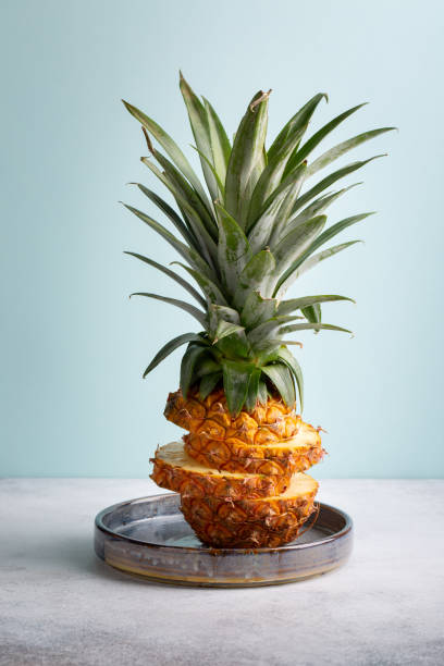 Sliced pineapple on pastel blue background. Copy space.