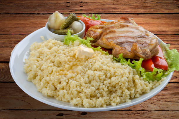 homemade cooked bulgur with Brussel sprouts in a plate, on a wooden table .