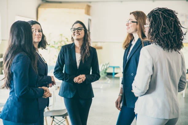 istock Group of smiling female workers talking in open space office 1220534623