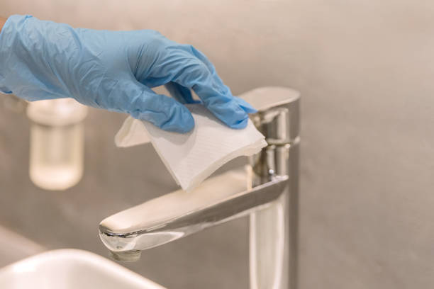 Cleaning bathroom to keep hygiene and avoid Coronavirus Close up shot Asian woman wiping basin faucet in bathroom to keep hygiene , in precautions of Covid 19 public restroom photos stock pictures, royalty-free photos & images