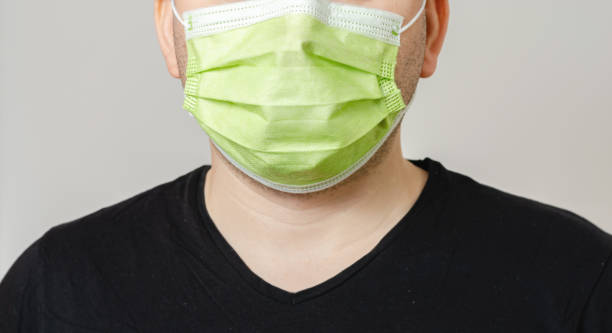 istock Young  man with a surgical  mask on his face protecting himself from the transmission of diseases and covid-19. Dust  and smog protection for people with asthma . 1220535366