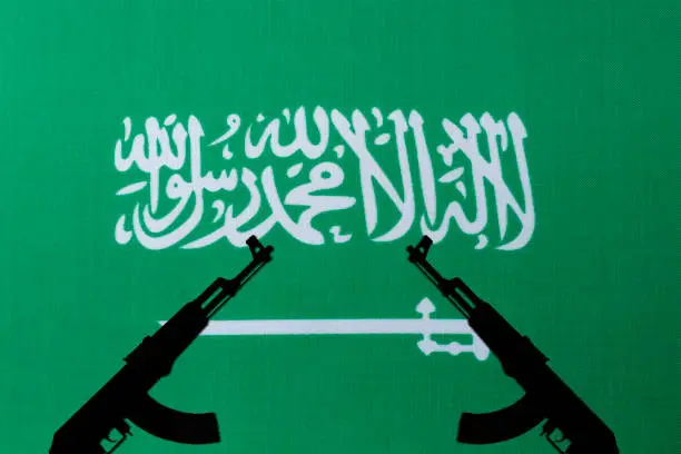 Photo of Saudi Arabia flag and the silhouette of the weapon.