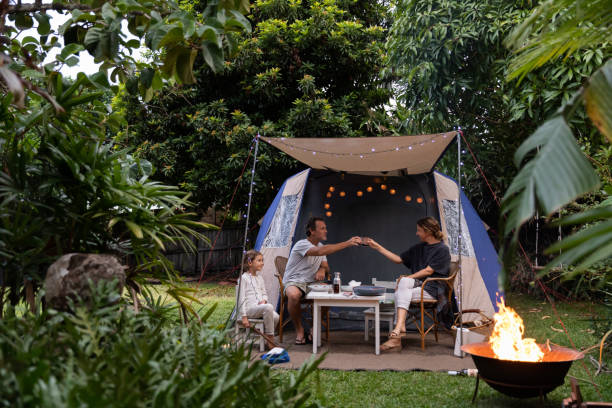 Family Camping in Backyard Real life Aussie parents cheers over a glass of red wine while camping in their backyard camping stock pictures, royalty-free photos & images
