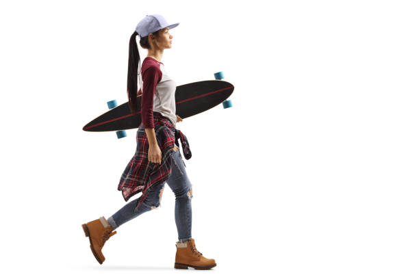 nastoletnia dziewczyna spacerująca i niosąca longboard - skateboarding skateboard teenager child zdjęcia i obrazy z banku zdjęć