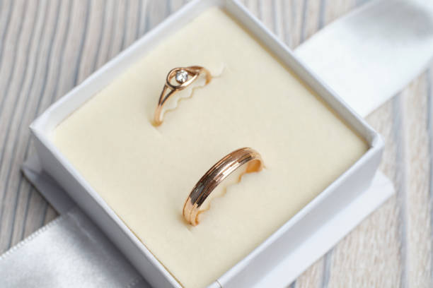 istock Gold wedding rings in a white box on a wooden background. 1220539909