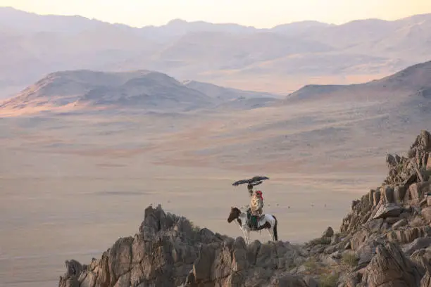 Photo of Lonely kazakh eagle hunter on an epic cliff edge.