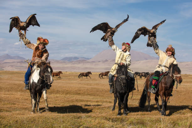 馬に乗ってゴールデンワシを抱いているワシハンターのグループ。 - inner mongolia ストックフォトと画像