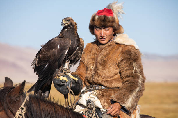 istock Kazakh eagle hunter with his eagle and horse. 1220541500