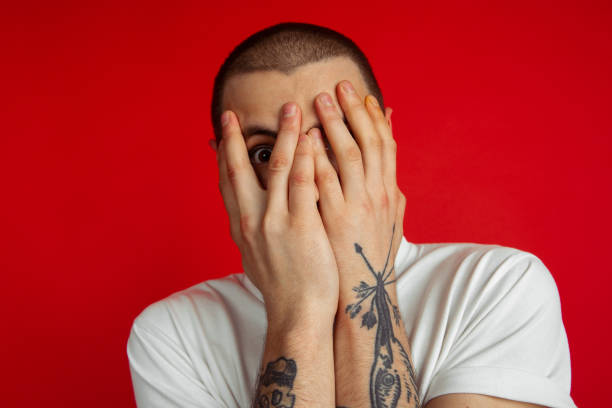 istock Caucasian young man's portrait on red studio background, emotinal and expressive 1220541884