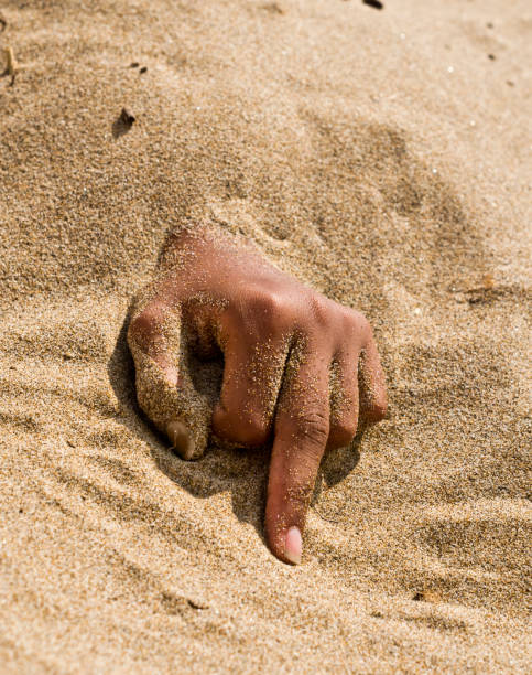 istock Finger gesture, hand in the sand makes a vulgar sign 1220542144