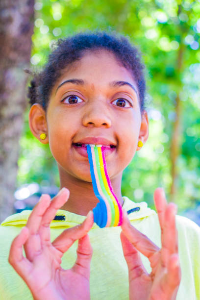 istock happy little girl eats a soft colored licorice 1220542195