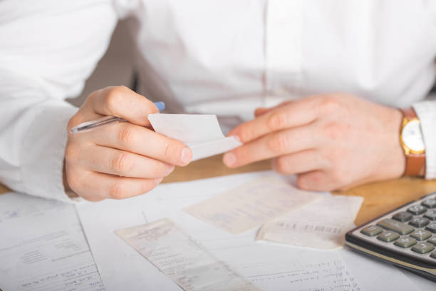 istock Hands of businessman analyzing invoice on laptop while checking bills. Rear view of  checking invoice while matching them on computer. Closeup of man hands calculating financial expenses. 1220545362