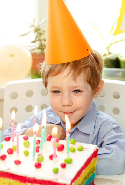 istock Beautiful kid. Birthday cake with candles, bright lights 1220545574