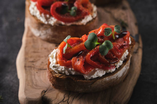 sanduíche com queijo macio e pimentão vermelho assado em uma tábua de madeira. - antipasto roasted pepper bell pepper pepper - fotografias e filmes do acervo