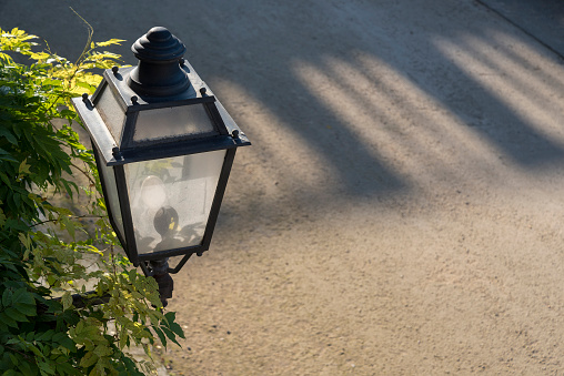 Vintage iron lantern, outdoor garden street wall metal electrical lamp in town or village.