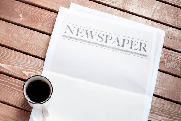 istock Newspaper and coffee on wooden background 1220549926