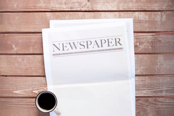 istock Newspaper and coffee on wooden background 1220549941