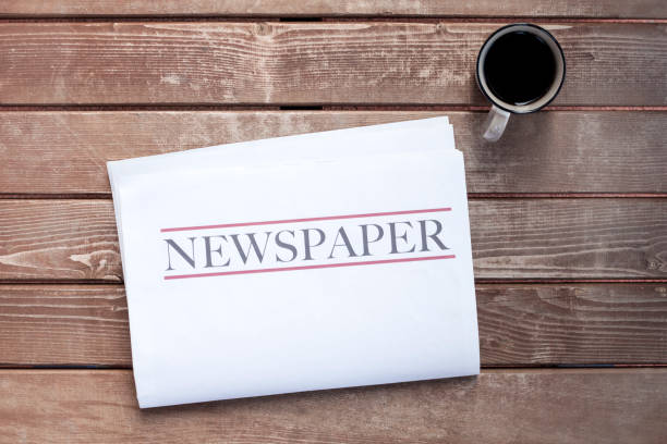 istock Newspaper and coffee on wooden background 1220549943