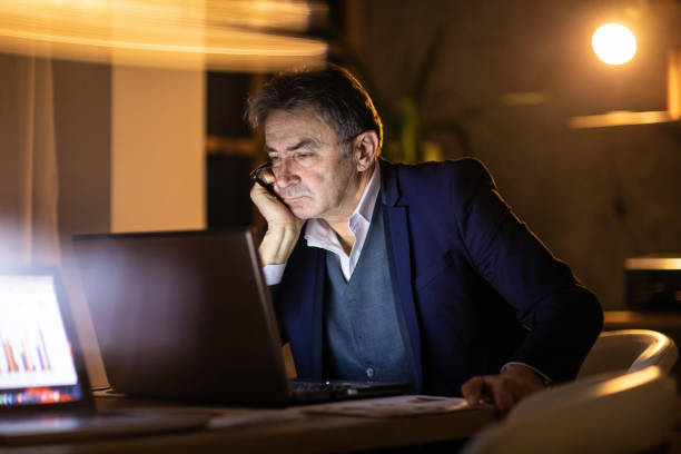 istock Tired man working late at night to get the job done 1220552629