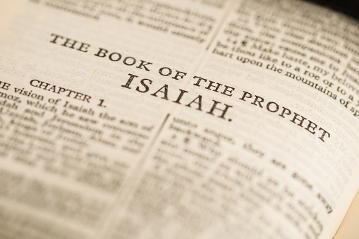 Close up macro image of a page from the bible showing ‘The Book of Isaiah’.