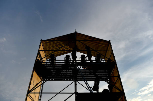 istock Technical staff and equipment silhouetted against sunset light preparing for a music concert 1220552933