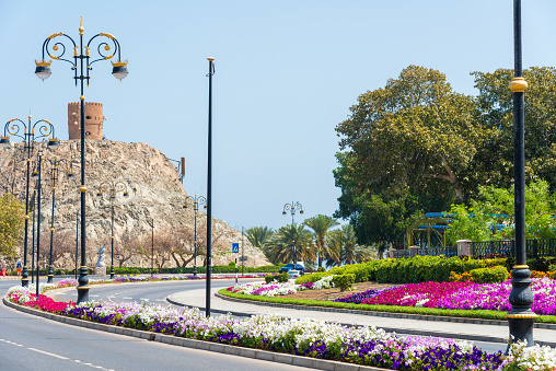 Muscat, Oman - March, 17. 2019 - Al Bahri Road im Muscat along the bay of the Sultan Qaboos Road. The beautiful colorful promenade with a lot of patterns in the bottom is a popular walk for locals and tourists. On the hill the Mutrah Fort