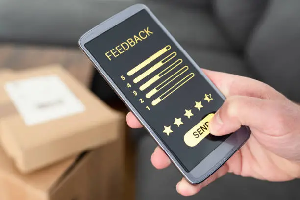 Photo of close-up of person giving positive feedback on smartphone after delivery of ordered items