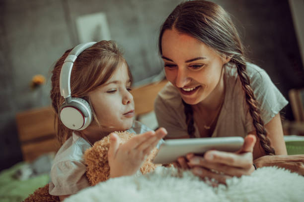 istock Mother and her daughters are surfing the net from the bed 1220558548