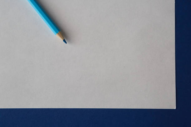 istock Blue colored pencil lying on a bright blue and white background 1220558675