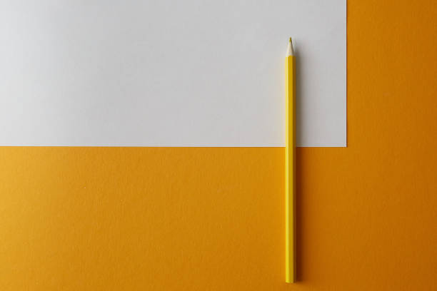 istock Yellow colored pencil lying on a yellow and white background 1220558751