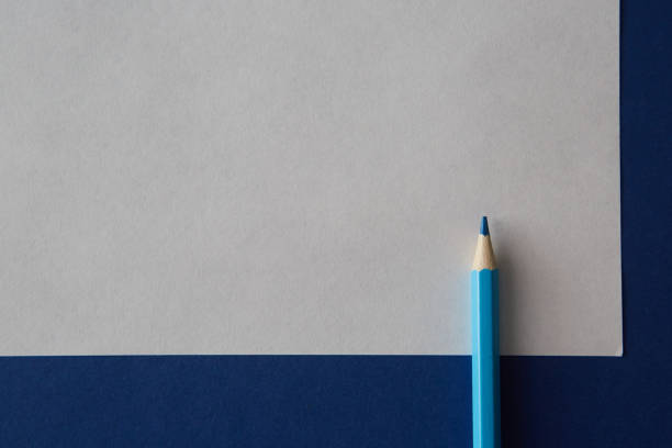 istock Blue colored pencil lying on a bright blue and white background 1220558806