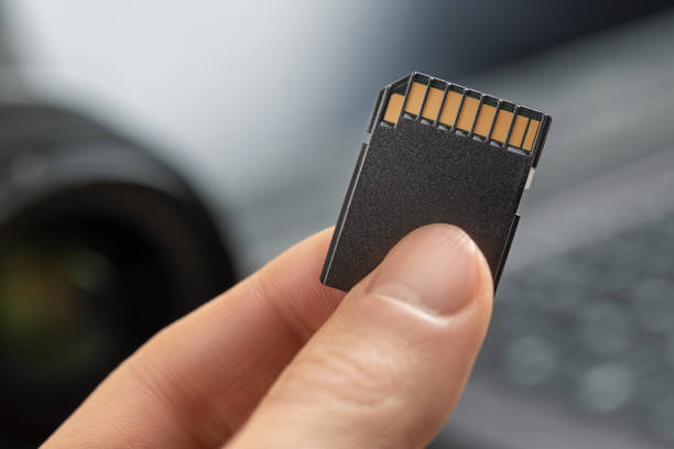 istock SD memory card close up holding in fingers 1220558839