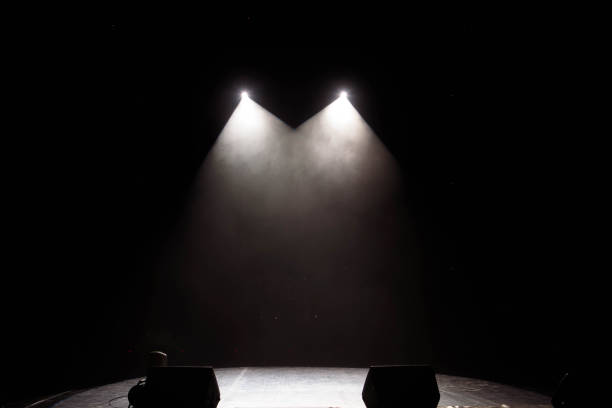 istock The light of searchlights in smoke on stage. 1220560072