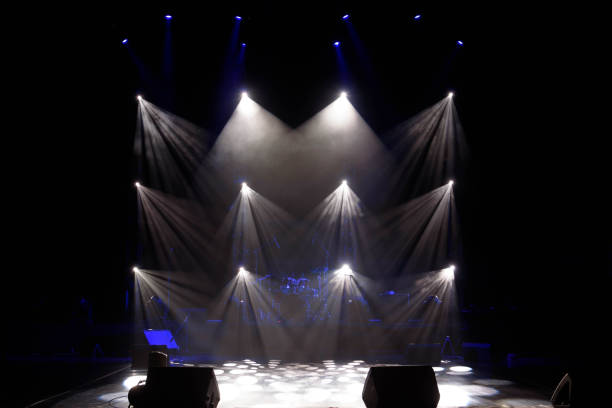 istock The light of searchlights in smoke on stage. 1220560090