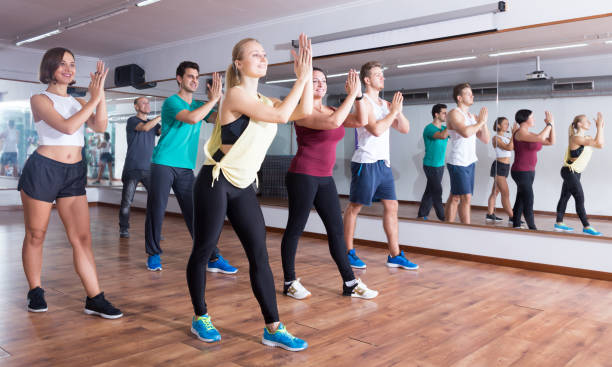 istock Happy positive people learning zumba steps 1220562322
