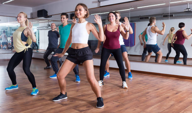 Friendly positive people learning zumba steps Friendly positive people learning zumba steps in dance hall curtseying stock pictures, royalty-free photos & images