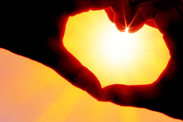 istock Hands forming a heart shape over the sun 1220566132